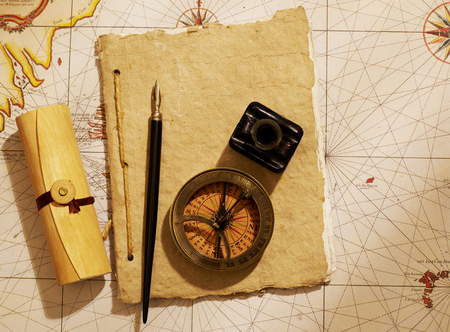 Ship's journal and compass over old map from XVIII century