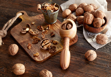 Walnuts and nutcracker on wood tableの写真素材