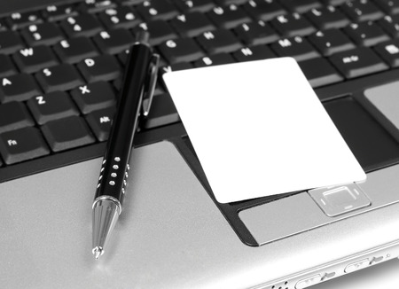Business card and pen on laptopの写真素材