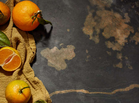 Fresh oranges with orange branches on rustic wooden table
