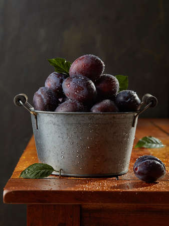 Juicy fresh plums on wooden tableの写真素材