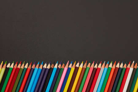 Multi-colored pencils on black background