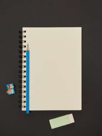 Blank paper notepad and school supplies on blackboard
