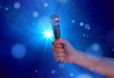 Holding a microphone on stageの写真素材