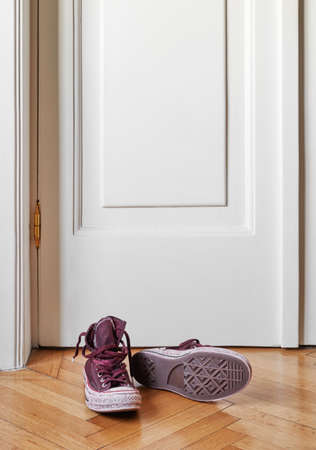 Used canvas shoes and skateboard on the floorの写真素材