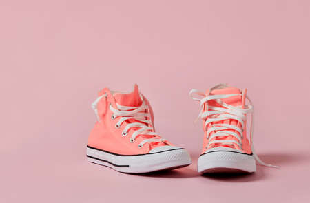 Pink canvas shoes on pink background