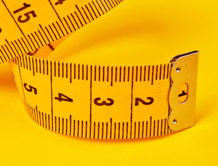 Tape measure on yellow backgroundの写真素材