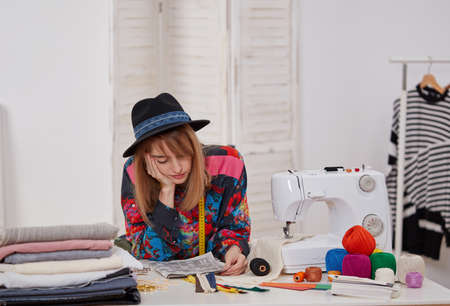 Young fashion designer thinking at the worktable