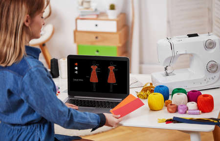 Young tailor woman working on laptop