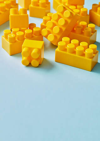 Plastic yellow toy blocks on blue backgroundの写真素材