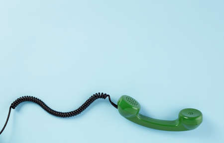 Rotary green phone receiver on blue backgroundの写真素材