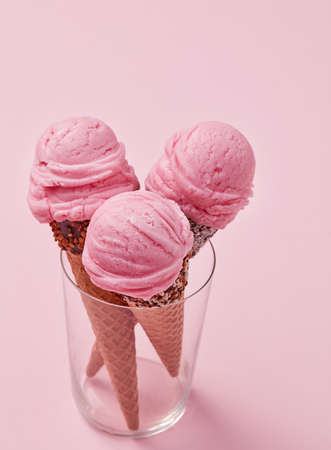 Strawberry ice cream cones on pink background