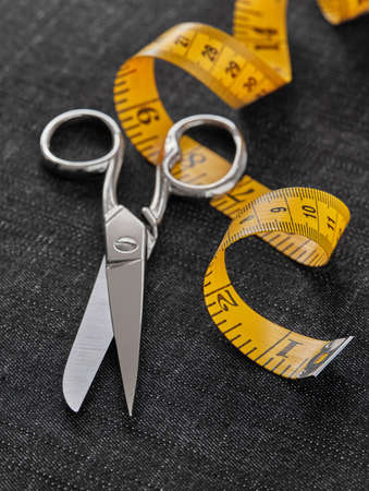 Tailor scissor and tape measure on textileの写真素材