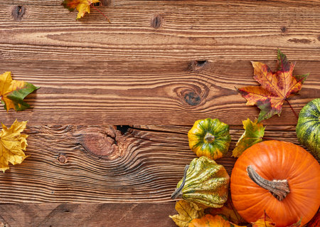 Fall pumpkins and leaves on wooden backgroundの写真素材