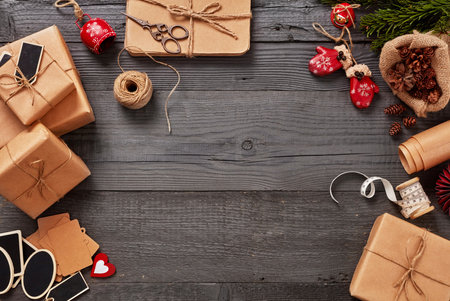 Christmas gifts sits on a wooden table alongside festive decorationsの写真素材