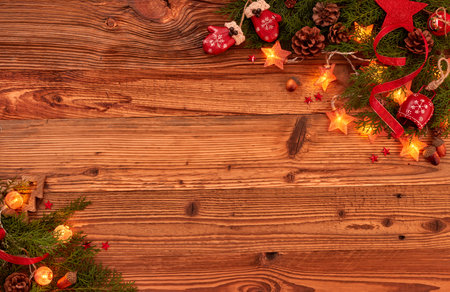 Christmas ornaments,fir branches, pine cones and Christmas lights on woodの写真素材