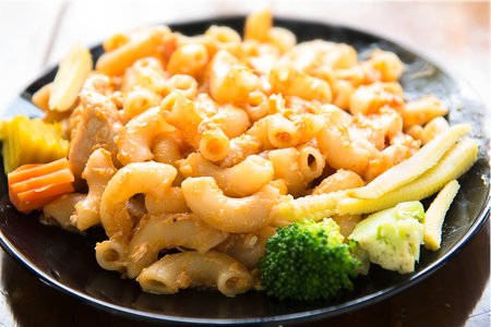 Fried macaroni with egg,chicken and vegetable in tomato sauce.の写真素材