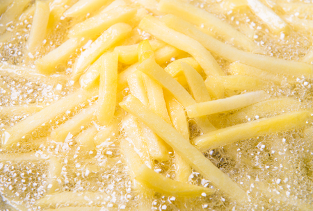 French fried potatoes frying in boiling oilの写真素材