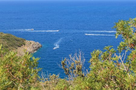 Aerial view of Tirrenic sea with boats, rocks, and vegetation of foreground. Copy space. Monte...