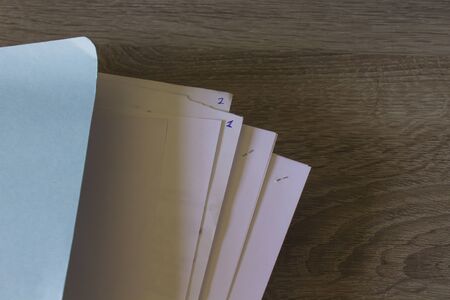 Closeup of sheets of paper on a wooden desk with copy spaceの写真素材