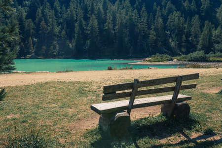 A park bench against Lake of fairies (Lago delle Fate in Italian) in Macugnaga, Italy.の写真素材