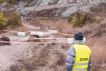 Back view of a race official staring at the circuit during a rally. Concept of racing cars, motorsports, rally, offroad, racing and safety during motorsports competions. Copy space.の写真素材