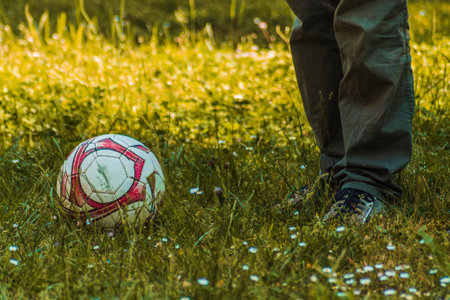 High angle view of mens legs and feet. Man ready to kick the ball with his foot, playing soccer outdoors. Copy space.の写真素材