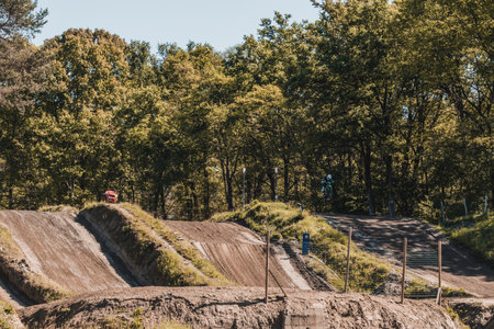 High angle view of a motocross track. On the right side of the track a biker is jumping. Copy space. Concept of motocross, extreme sports.の写真素材