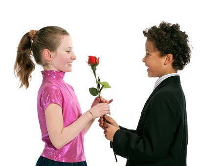 boy giving a rose to a girl, isolated on a white backgroundの写真素材
