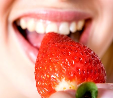 beautiful girl eating a strawberry, isolated on whiteの写真素材