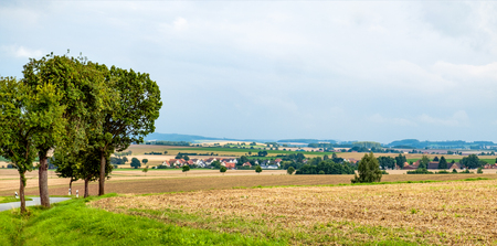 Asphalt road, the village and the mountains at the background. Harz. Germanyの写真素材
