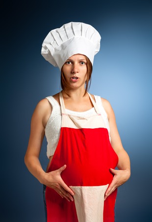 A bun in the oven. Pregnant woman cook.の写真素材