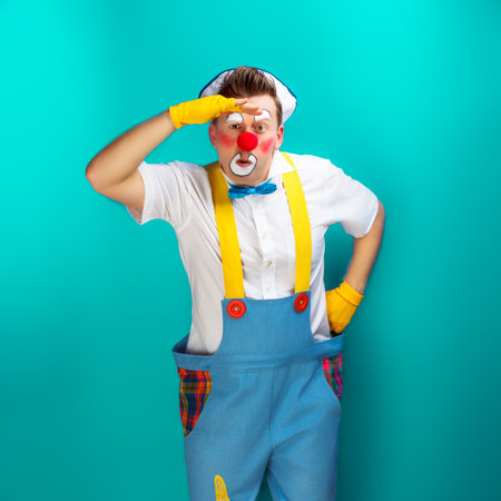 A funny clown with smiling joyful expression, at colored backgroundの写真素材