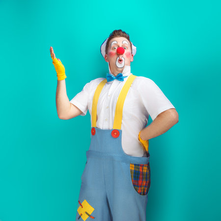A funny clown with smiling joyful expression, at colored backgroundの写真素材