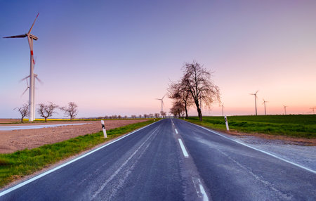Empty Road at Sunset with Wind Turbines in the Distance