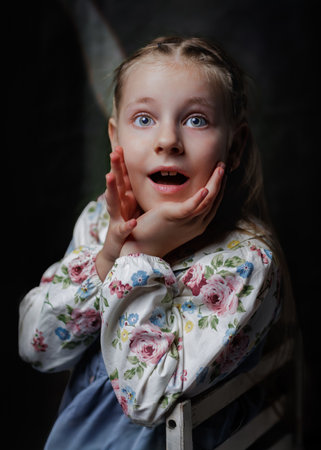 Photographs of a girl in a floral dress on a dark background, showcasing a range of emotions and...