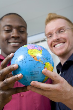 Multi-ethnic businessmen holding globe