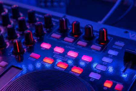 dj table with headphones mixing music flashy colors blue purple