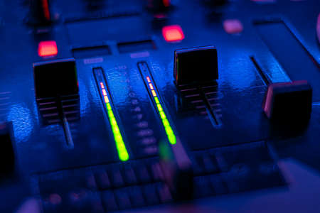 dj table with headphones mixing music flashy colors blue purple
