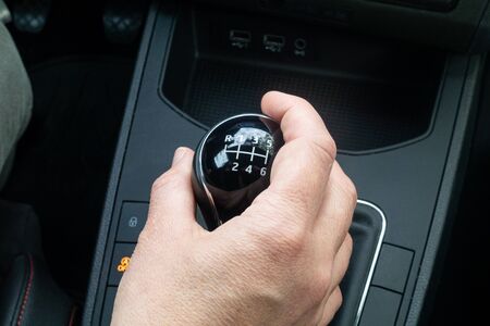 hand on a black auto hand gear with six gears and reverse