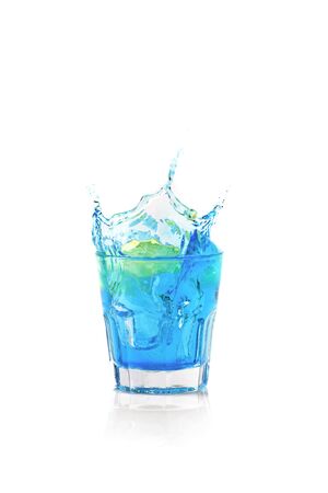 Summer exotic cocktail with ice, lemon and splashes on isolated white backgroundの写真素材
