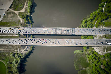 Cars driving through the bridge between two islands. Top down view from drone.