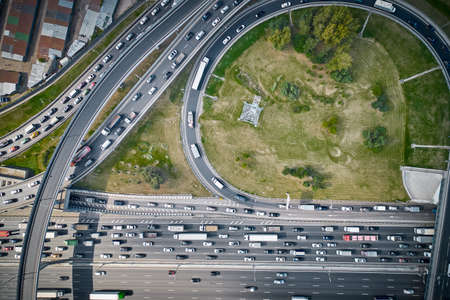 Shot from above on big junction with curves, overpasses and exits. A lot of cars