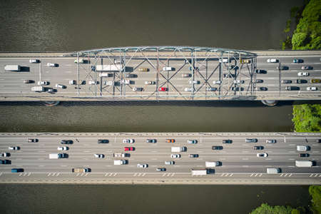 Look from above on double bridge over river. Near coast. Two parallel ways.