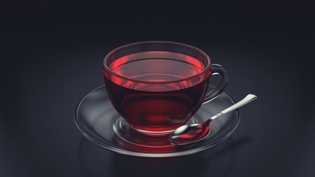 Glass cup of tea with spoon and saucer on dark backgroundの写真素材