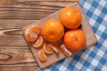 Fresh mandarins on table with checkered clothの写真素材