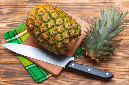 Sliced pineapple on table with knifeの写真素材