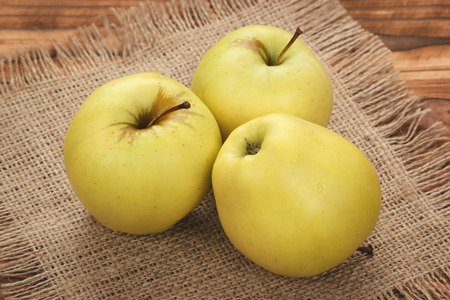 Green yellow apples on burlap backgroundの写真素材