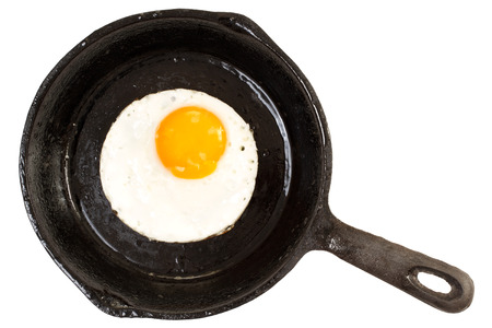 Fried chicken egg on iron pan. Top view, isolated on white backgroundの写真素材