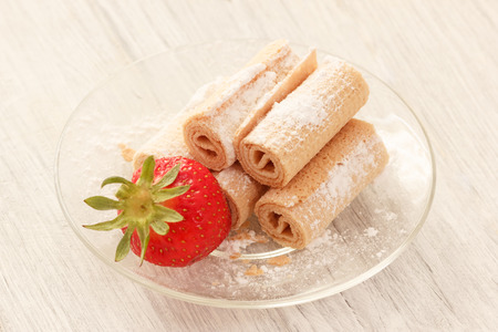 Waffle rolls with natural strawberry on glass plateの写真素材